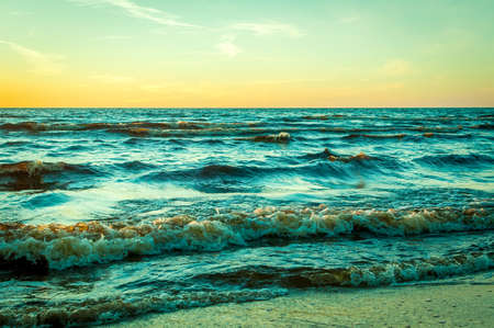 Sunset on the seaside with waves -orange with blueの写真素材
