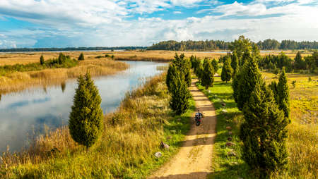 Autumn landscape of road along river with motorcycleの写真素材
