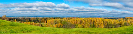 Autumn panorama of latvian forests and meadows under blue skyの写真素材