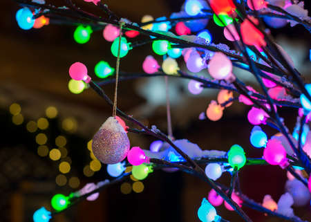 Christmas decoration - shiny ball with tree of colorful lights at nightの写真素材