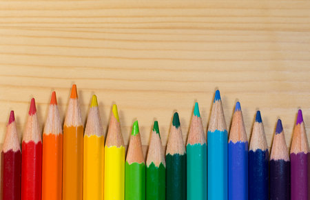Row of colorful pencils rainbow order on wooden tableの写真素材