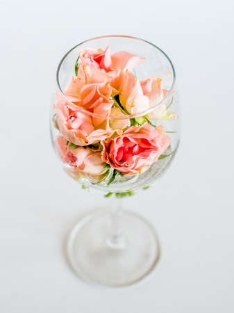 Glass with small rose flowers for wedding celebration white backgroundの写真素材
