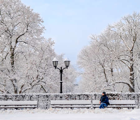 Street lantern with man on the bench cold winter dayの写真素材
