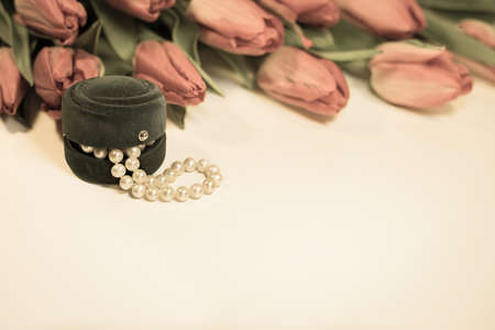 Red spring tulips with small box with pearls romantic presentの写真素材
