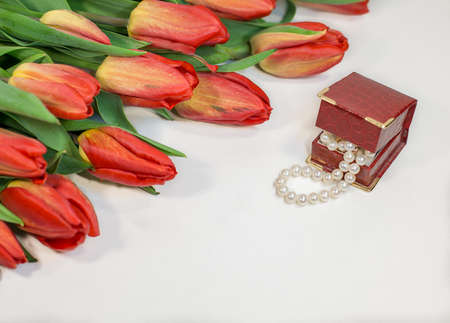 Red spring tulips with small box with pearls romantic presentの写真素材