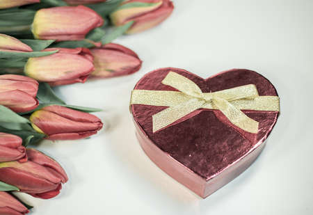 Red tulips with heart gift isolated on white background - spring flowers post card for celebrationの写真素材