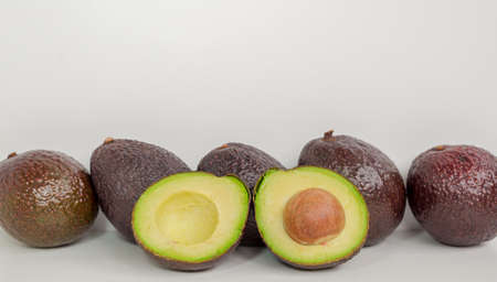 Brown avocado fruit isolated with green half with seed white backgroundの写真素材