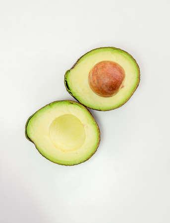 Avocado fruit isolated with green half with seed white backgroundの写真素材
