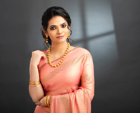 Beautiful indian woman in a pink dress against a dark background