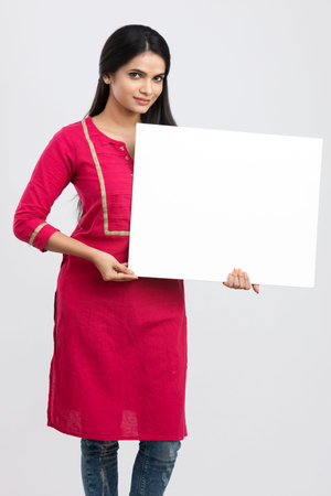 Portrait of a young asian woman holding a blank board isolated on white backgroundの写真素材
