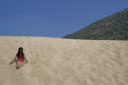 Girl enjoying sand bath on the banks of river near Hogenakkal falls, Karnataka and Tamil Nadu state border, India, Asia on January 14, 2014のeditorial素材