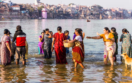 a group of women is taking a holy bath in the river Gangesのeditorial素材