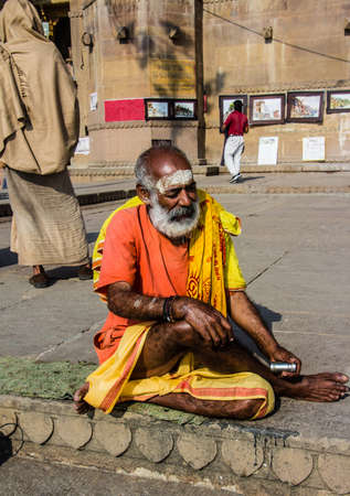 A sadhu, or holy man, sitting on the ghats of the holy hindu city of Varanasiのeditorial素材