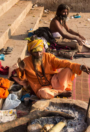 two sadhus sitting on the ghats of the holy city of Varanasiのeditorial素材