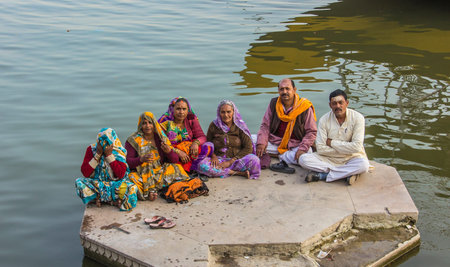 An indian family is sitting at the water f the ganges のeditorial素材