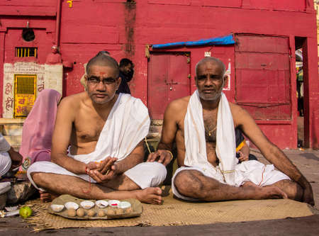 Two men sitting on the ghats of the holy city of Varanasiのeditorial素材