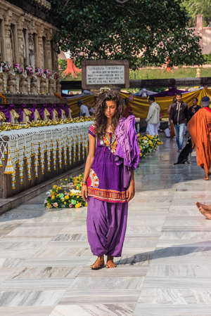 A beatiful girl, like many other people from all over the world, is circling mahabodhi temple, Indiaのeditorial素材