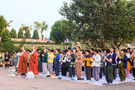 A group of buddhist believers praying near Mahabodhi temple, Indiaのeditorial素材
