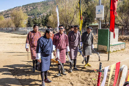 Archery is the national sport of Bhutan  These men in national costume are doing a little dance of joy after one of their team hit the aim のeditorial素材