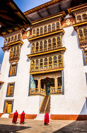 The impressive dzong of Punakha, Bhutan  Unrecognizable buddhist monks are walking over the courtyard  Dzongs are fortress like buildings which house a monastery and administrative offices のeditorial素材