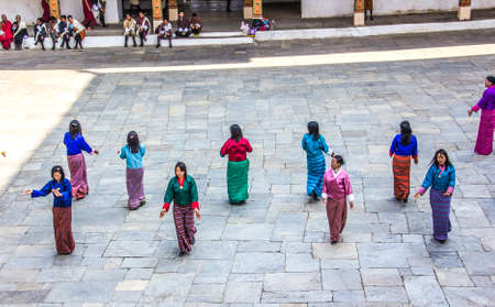 Female dancers are appearing in the dzong of Punakha, Bhutan  They are wearing the traditional costume for their dance  Dzongs are fortress like buildings which house a monastery and administrative offices のeditorial素材
