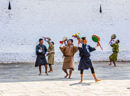 Male dancers are appearing in the dzong of Punakha, Bhutan  They are wearing the traditional costume for their dance and they have drums in their hands のeditorial素材