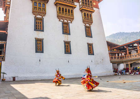 Two masked dancers at  drupchen festival in the dzong of Punakha, Bhutan  Drupchen festival is taking place yearly in march   all faces blurred のeditorial素材