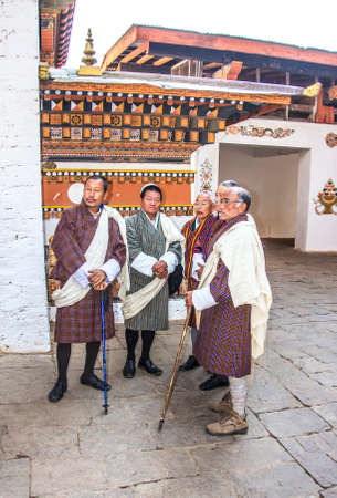 People are standing in the dzong of Punakha, Bhutan, waiting for the appearance of the dancers. Dzongs are fortress like buildings which house a monastery and administrative offices.のeditorial素材