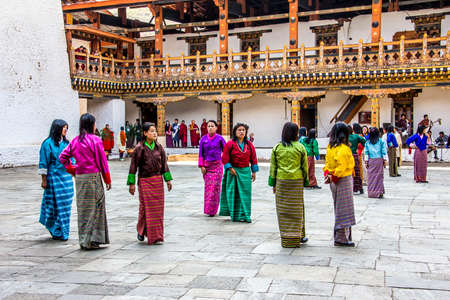 Female dancers are appearing in the dzong of Punakha, Bhutan  They are wearing the traditional costume for their dance  Dzongs are fortress like buildings which house a monastery and administrative offices のeditorial素材