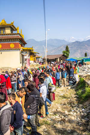 At the bumchu festival, Tashiding, Sikkim, Buddhist believers, men and women, are queuing in two lines to get into the temple  In the background is the himalaya のeditorial素材