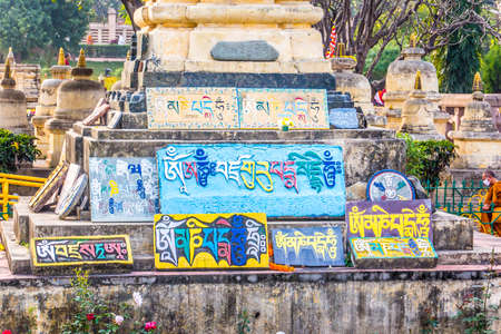 A stupa near Mahabodhi temple, Bodhgaya, India, with many stones, so called mani-stones, engraved with buddhist prayers and a dharma wheel.のeditorial素材