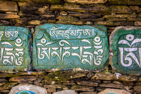 A mani wall in Tashiding, Sikkim, India, with stones, engraved with buddhist prayers in tibetan script.のeditorial素材