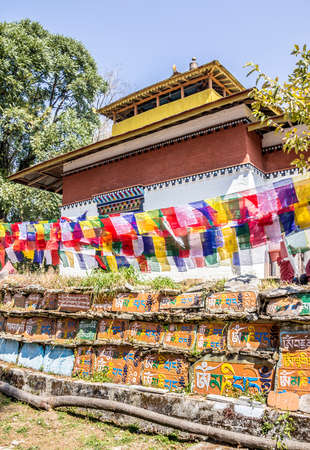 A beautiful temple behind a mani wall in Tashiding, Sikkim, India. Attached to the wall are  stones, engraved with buddhist prayers in tibetan script.の写真素材