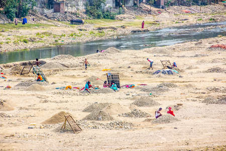 Siliguri, West Bengal, India: people are sieving gravel in a dry riverbed, to make some money.のeditorial素材