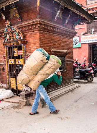 Many goods in kathmandu are still carried on the back through the narrow streets.のeditorial素材