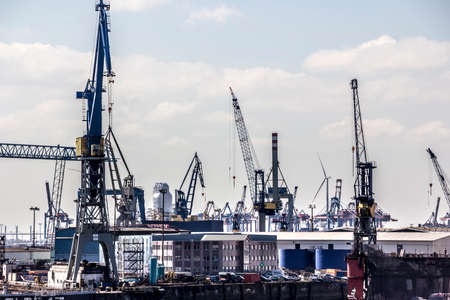 Cranes and other industial equipment are forming an industrial landscape.のeditorial素材