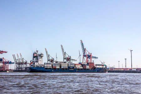 A container ship is in a container terminal in the harbor of hamburg, Germany. A ship lies not more than one day in the terminal.のeditorial素材