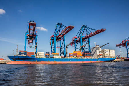 A container ship is in a container terminal in the harbor of hamburg, Germany. A ship lies not more than one day in the terminal.のeditorial素材