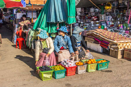 Three myanmar women selling oranges on the market of Keng Tung in the north of Myanmarのeditorial素材