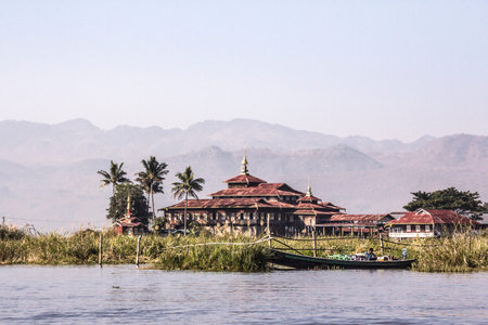 A monastery on stilts at Inle lake Myanmar. In the background are the mountains.のeditorial素材