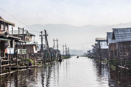 The "main road" of a stilt village at the Inle lake, Myanmar. In the background are the mountains.のeditorial素材