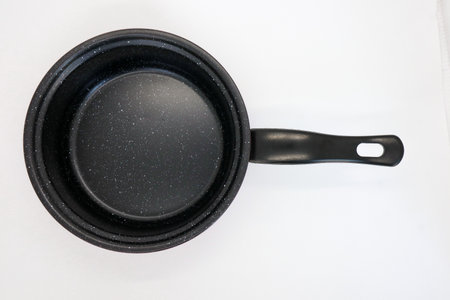 Black and red non-stick pan for cooking in the kitchen, pan for cooking vegetables and cooking water for household needs, isolated on whiteの写真素材