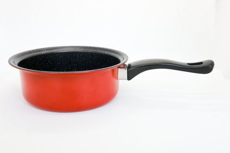 Black and red non-stick pan for cooking in the kitchen, pan for cooking vegetables and cooking water for household needs, isolated on whiteの写真素材