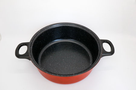 Black and red non-stick pan for cooking in the kitchen, pan for cooking vegetables and cooking water for household needs, isolated on whiteの写真素材