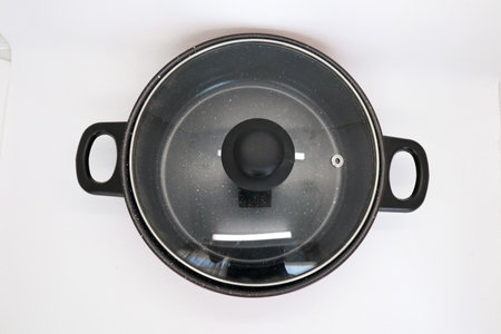 Black and red non-stick pan for cooking in the kitchen, pan for cooking vegetables and cooking water for household needs, isolated on whiteの写真素材