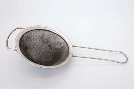 Tea filters or cooking oil filters are made of used stainless steel isolated on whiteの写真素材