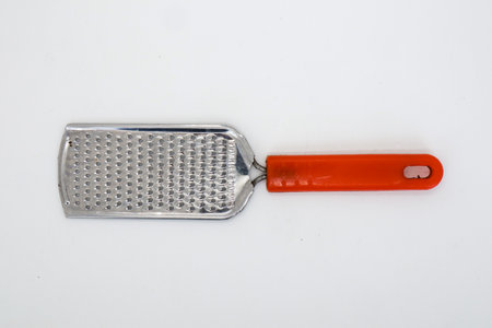 Red stainless steel cheese grater isolated on whiteの写真素材