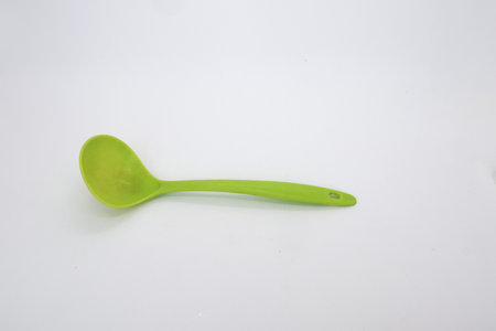 Green vegetable scoop or vegetable ladle isolated on whiteの写真素材