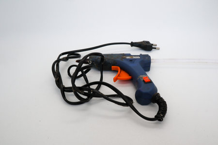 Hot glue is a type of glue that has stronger adhesive qualities and is long-lasting in whiteの写真素材