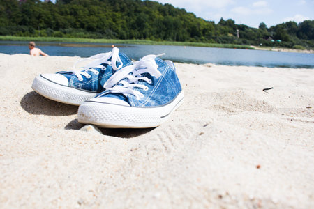 blue sneakers on white sand